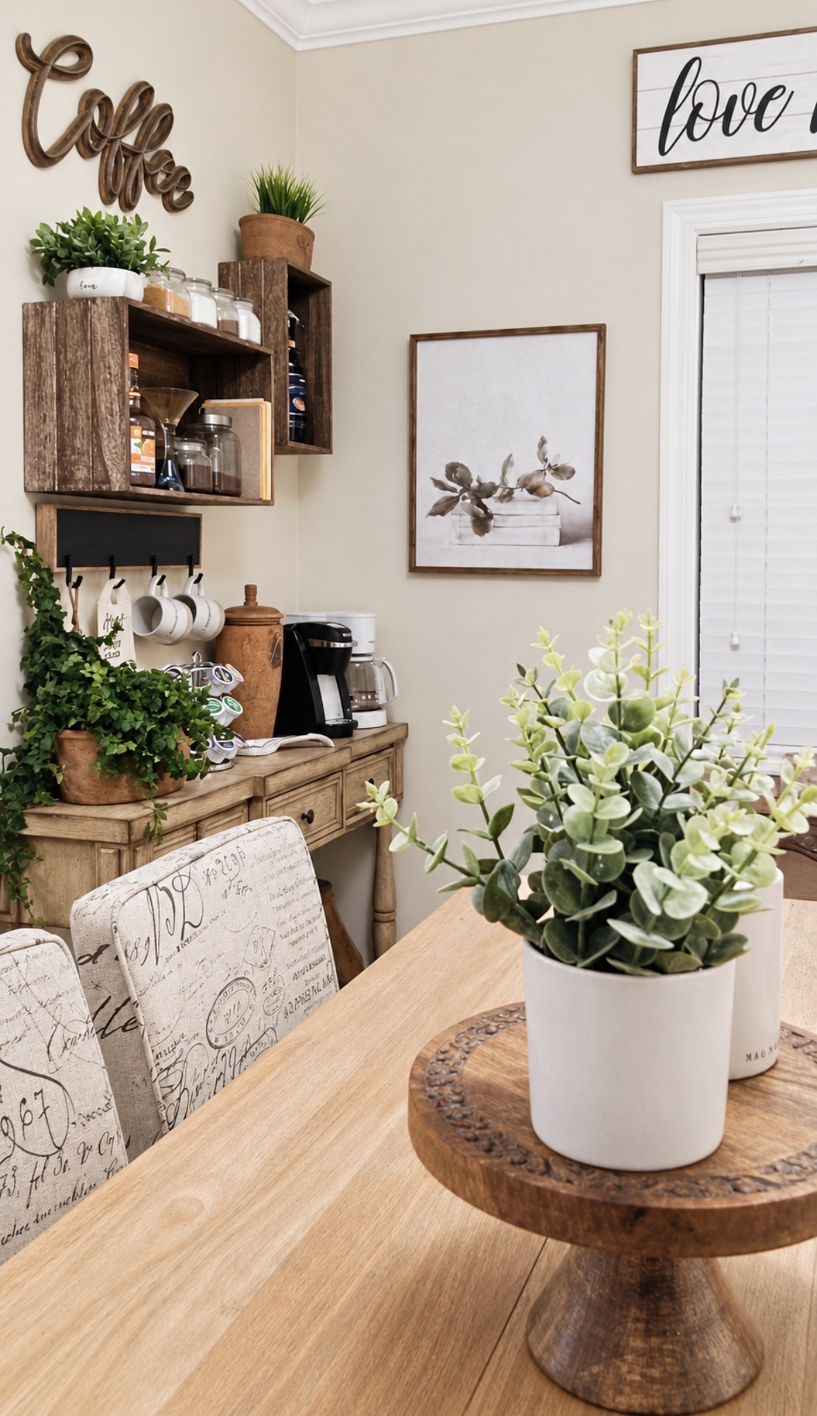 Warm dining nook with layered wood, greenery and a collected coffee station